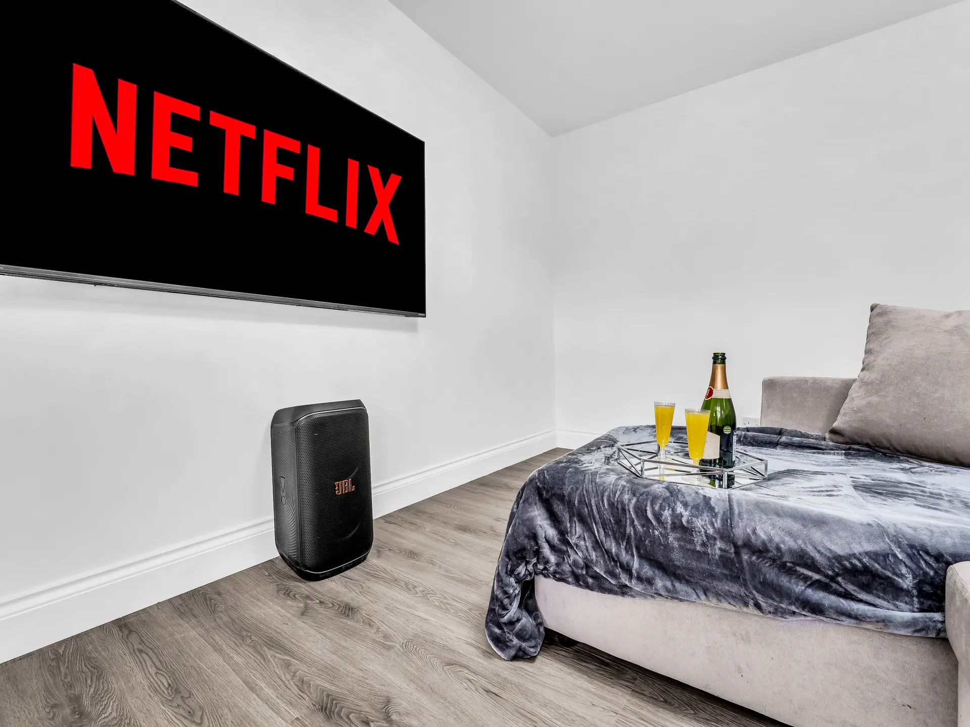 Bright apartment living room with sofa, television, and welcome setup